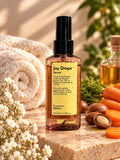 maad Joy Drops 100 ml hair serum spray bottle beside towels, argan nuts and carrots