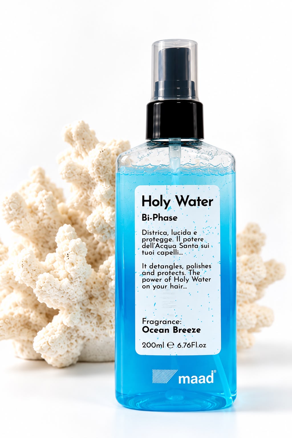 Clear spray bottle of blue maad Holy Water Bi-Phase 200 ml beside white coral