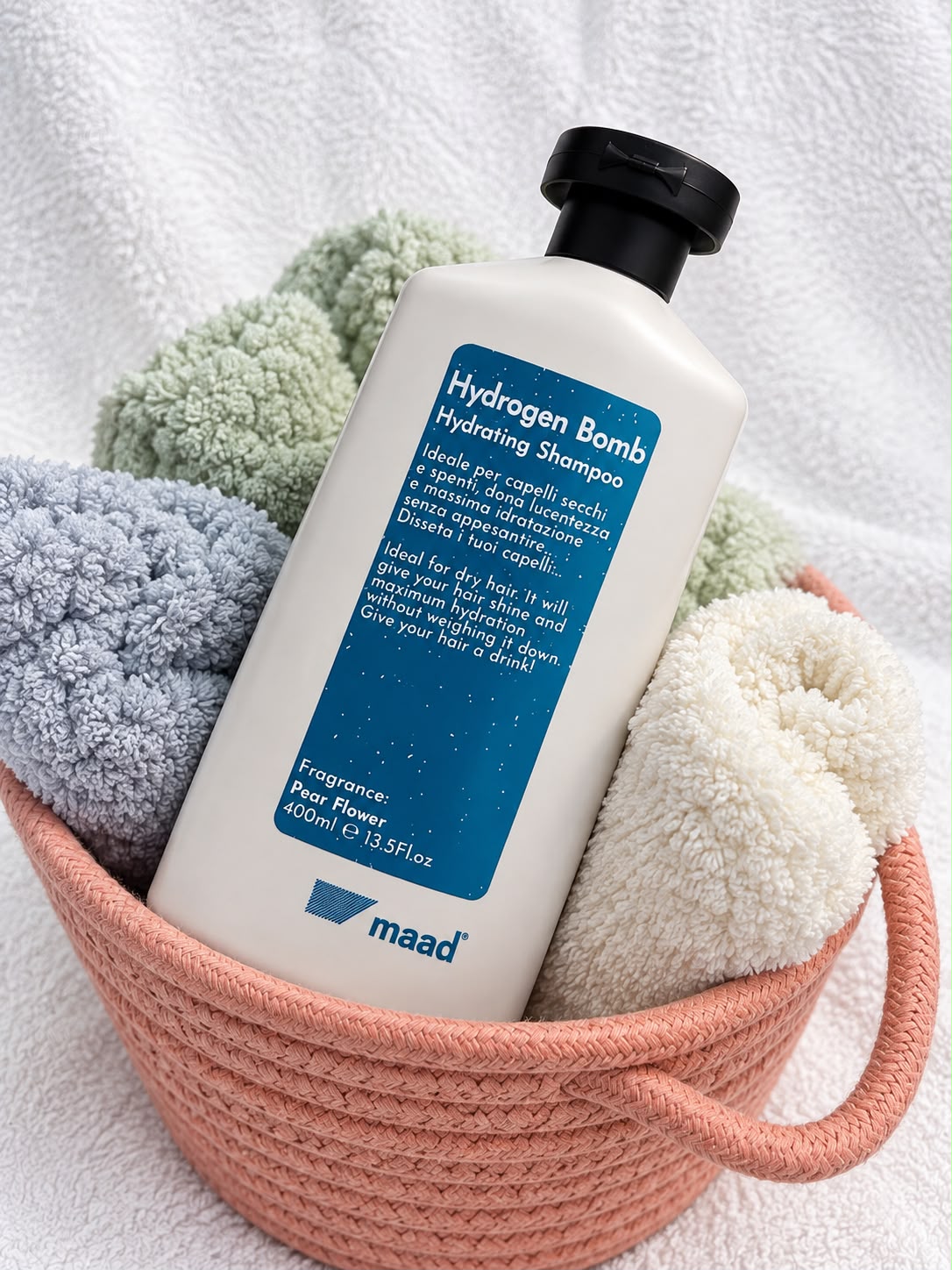 maad Hydrogen Bomb Hydrating Shampoo 400 ml bottle among rolled towels in a pink basket
